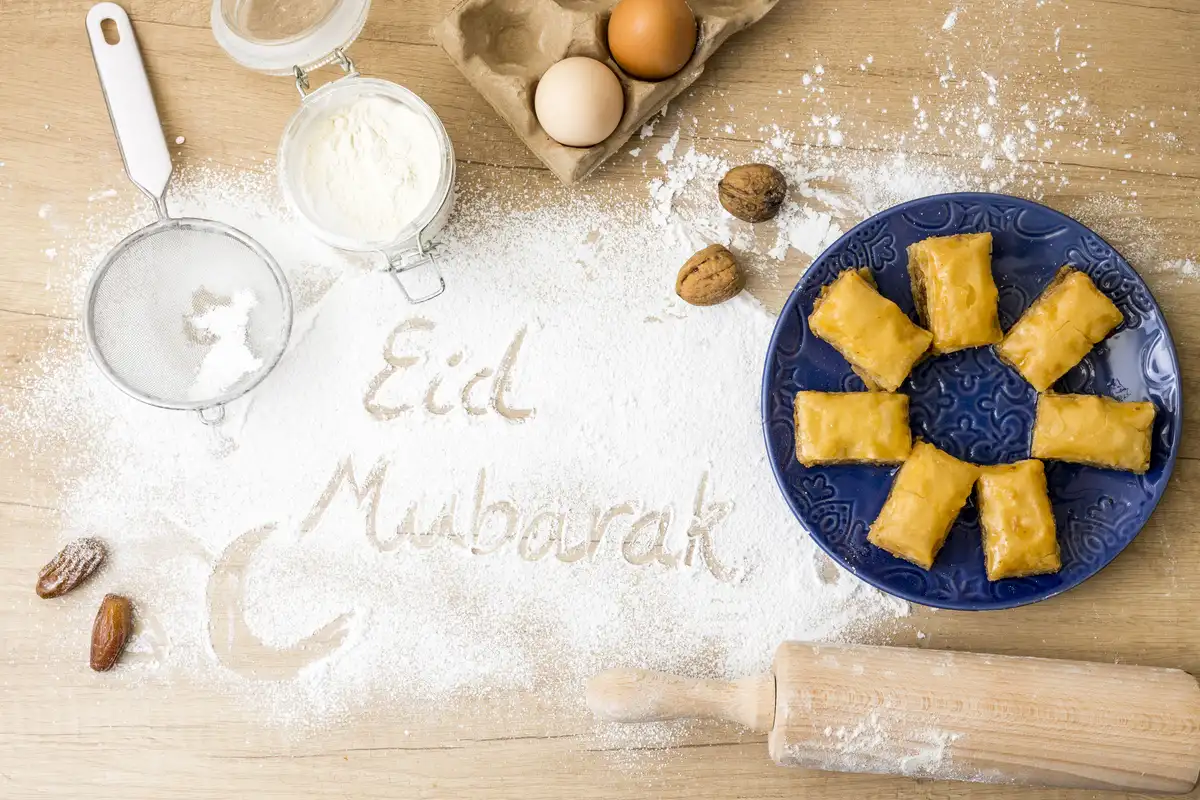 eid mubarak inscription flour with eastern sweets plate